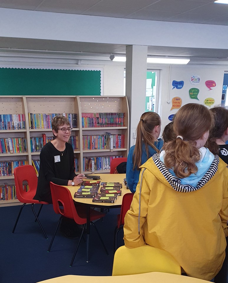 Ally with young readers in library at book signing at Padnell Juniors